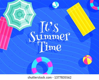 Texto elegante Es la hora de verano con la vista superior de elementos de la playa como bola, salvavidas y paraguas sobre fondo ondulado azul.