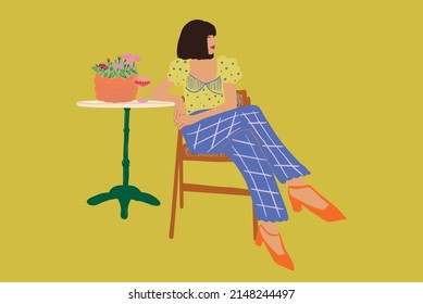 Stylish woman sitting by the round table with flowers and drink at cafe. Vector illustration isolated on background