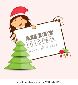 Stylish X-mas tree with cute little girl in Santa cap holding board for Merry Christmas and Happy New Year celebrations. 