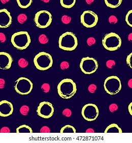 Stylish yellow and pink polka dot. Abstract background with round brush strokes. Hand drawn texture on dark blue background. Dry brush and rough edges. Vector seamless pattern.