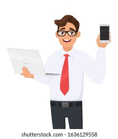 Stylish young business man holding laptop and showing mobile, cell phone. Trendy person using or working computer. Male character design illustration. Modern technology, lifestyle in vector cartoon.
