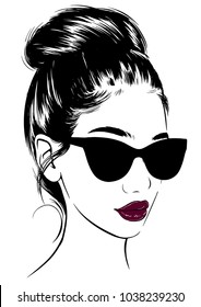 Stylish young woman in sunglasses and bun