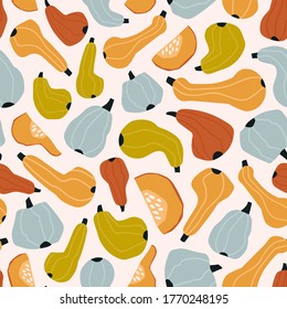 Stylized colored pumpkins isolated on a light pink background. The autumn harvest. Background with vegetables. Hand drawn vector seamless pattern. Used for fabric, wrapping paper, wallpaper.