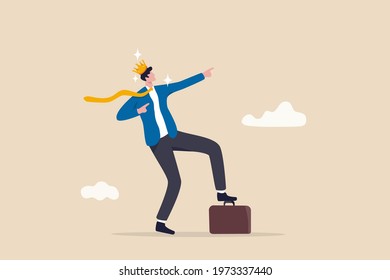 Success businessman king proud of his achievement, work happiness or self esteem, freedom or entrepreneurship concept, cheerful businessman wearing king crown step on briefcase pointing to the sky.