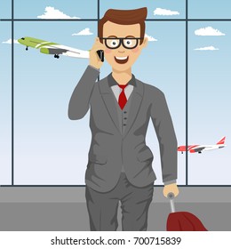 Successful cute businessman with glasses and suitcase talking on the phone at airport