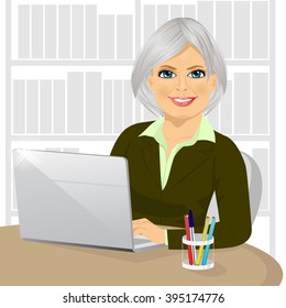 successful mature businesswoman working typing on her laptop at office