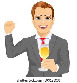 successful young businessman holding a glass of champagne while raising his fist