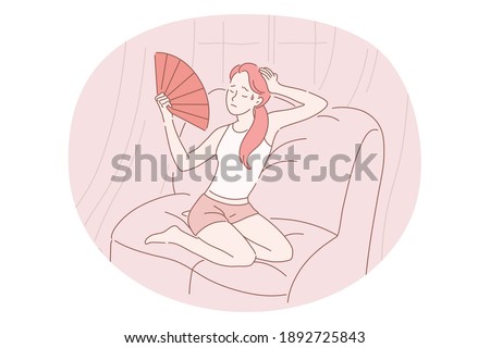 Suffering from heat concept. Young stressed girl cartoon character sitting with hand fan and suffering from incredible heat in room indoors vector illustration 