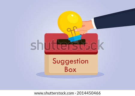 Suggestion vector concept. Hand putting a light bulb into a suggestion box
