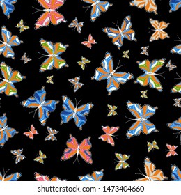 Suitable. Seamless background from bright butterflies. Seamless multicolored background with flying moths. Vector. Beautiful colorful butterflies chaotically fly on black, blue and orange colors.