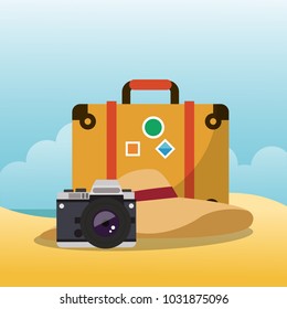 Suitcase and camera on beach