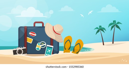 Suitcase, camera, smartphone and beach accessories on the sand: vacations on the tropical beach concept