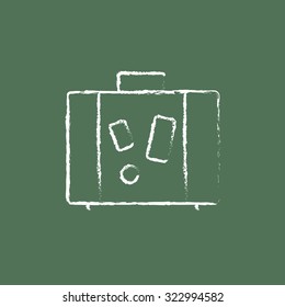 Suitcase hand drawn in chalk on a blackboard vector white icon isolated on a green background.