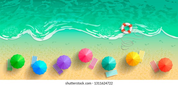 Summer beach background. Top view of the sea and the beach with umbrellas, deck chairs and a life preserver. Traces of bare feet in the sand along the line of the surf.