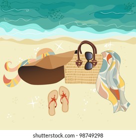 Summer at the Beach - stylish accessories on golden sand, at the beach: summer hat, straw bag, flip flops, sunglasses and colorful silk scarf or sari