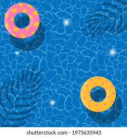 Summer blue aqua textured background. Swimming pool with pool floats and leaves shadows