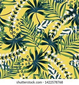 Summer bright original seamless pattern with tropical leaves and plants on a yellow background. Vector design. Jung print. Floral background. Printing and textiles.