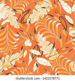 Summer bright seamless pattern with tropical leaves and plants on orange background. Vector design. Jung print. Floral background. Printing and textiles.