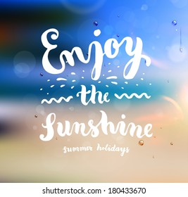 Summer Design. Blur Beach Background. Hand Drawn Lettering Vector. Enjoy the Sunshine