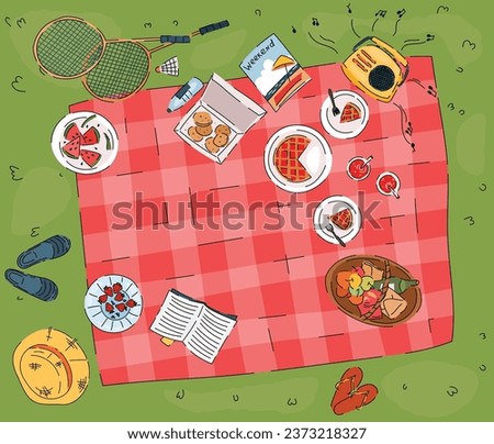 Summer picnic on green grass top view. Basket with bread and bottle of wine, pie in plates, radio