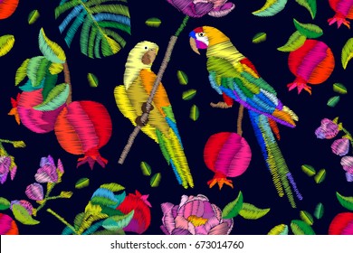 Summer pomegranate garden. Seamless vector pattern with exotic birds, fruits, palm leaves and flowers. Embroidered texture. Vintage textile collection.