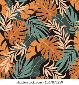 Summer seamless tropical pattern with bright yellow and green plants and leaves on a brown background. Beautiful print with hand drawn exotic plants. Seamless pattern with colorful leaves and plants.