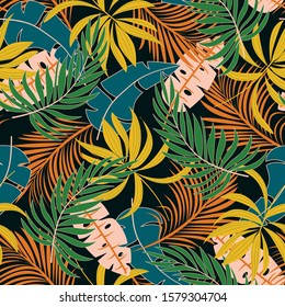 Summer seamless tropical pattern with bright yellow and green plants and leaves on a dark background. Modern abstract design for fabric, paper, interior decor. Exotic wallpaper.