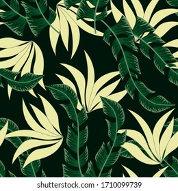 Summer seamless tropical pattern with bright plants and leaves on a black background. Beautiful seamless vector floral pattern. Exotic wallpaper. Beautiful print with hand drawn exotic plants.