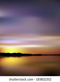 Summer Sunset over a glassy smooth lake as seen from the beach