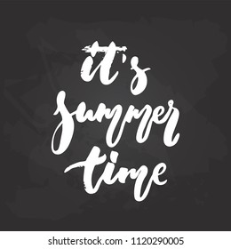 It's summer time - hand drawn seasons holiday lettering phrase isolated on the black chalkboard background. Fun brush ink vector illustration for banners, greeting card, poster design