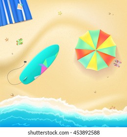 Summer travel background. Sunny sandy beach with umbrella, mat, slippers and a surfboard. Tropical seashore with a view of the surf, top view.