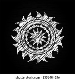 sun icon inside chalk emblem written on a blackboard