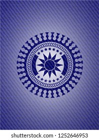 sun icon inside emblem with denim texture