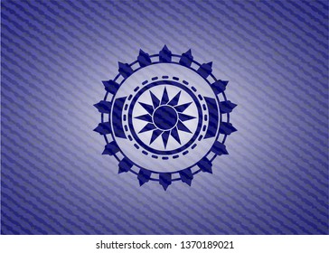 sun icon inside emblem with jean background