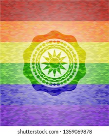 sun icon inside emblem on mosaic background with the colors of the LGBT flag