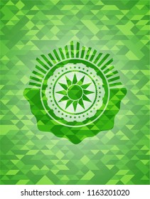 sun icon inside green mosaic emblem