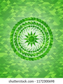 sun icon inside green mosaic emblem