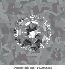 sun icon inside grey camouflage emblem