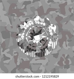 sun icon inside grey camouflaged emblem