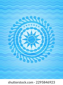sun icon inside light blue water wave badge. 