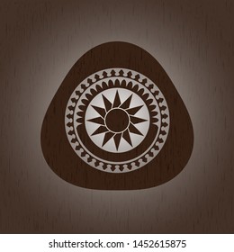 sun icon inside wooden emblem