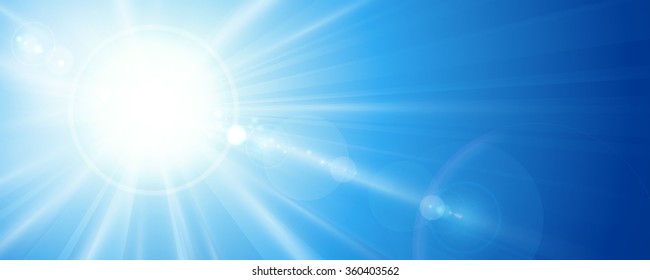 Sun rays and lens flare in a bright blue sky in horizontal, panorama format. Space for your text.
