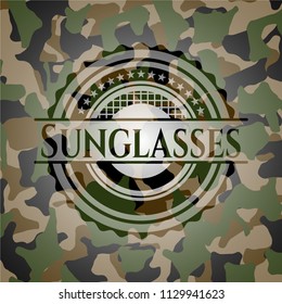 Sunglasses on camouflage texture