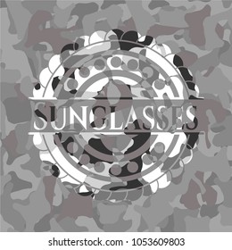 Sunglasses on grey camo texture