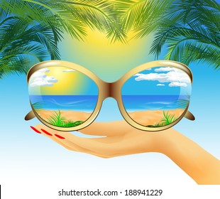 Sunglasses with the reflection of the summer sea landscape lie on hand