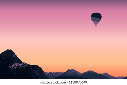 Sunset against the background of a high snow mountain