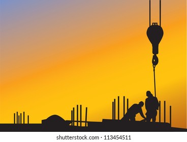 The sunset background with silhouettes of construction workers