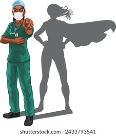 A super hero black woman doctor or nurse medical healthcare health professional in scrubs and mask PPE pointing. Revealed to be a superhero by her shadow.