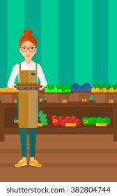 Trabajador de supermercado con caja llena de manzanas.