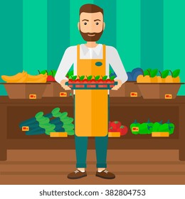 Supermarket worker with box full of apples.